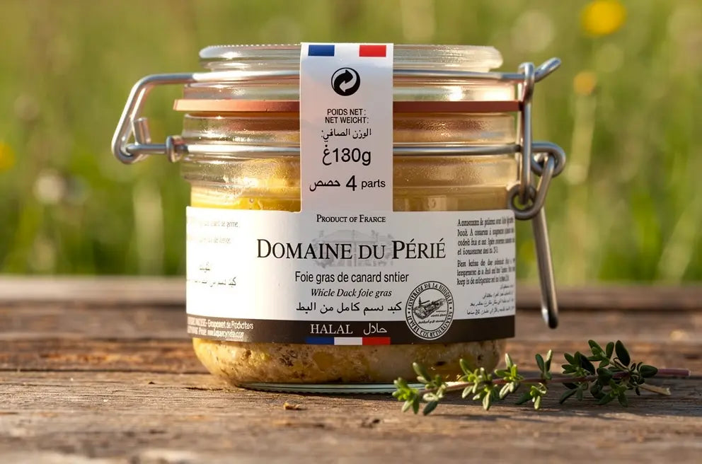 Pot à foie gras halal Domaine du Périé en bocal à fermoir métallique, étiquettes détaillées et ruban tricolore, posé sur bois avec thym au premier plan.
