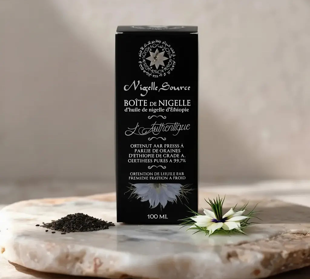 Boîte noire d’huile de nigelle éthiopienne Nigelle Source sur pierre, lotus blanc et pavot de nigelle à côté, texte élégant sur l’emballage 100 ml