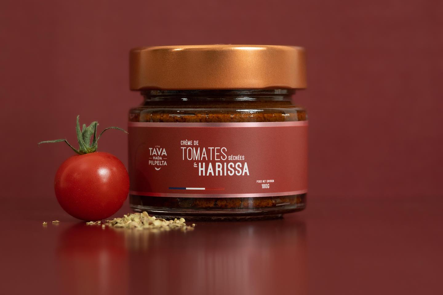 Crème de tomates séchées et harissa Tava Hada Pilpelta posée devant une tomate