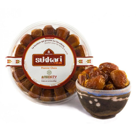 Datees Sukkari en boîte et bol avec dates fraîches, emballage rond orange et décoration floral.